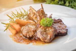 Rack of lamb served with baby carrots and a sauce